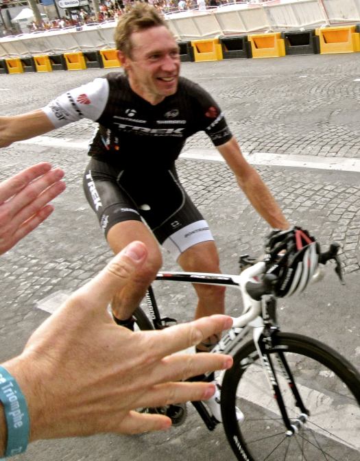 Jens Voigt high-fiving fans at the end of Tour de France 2014 in Paris.