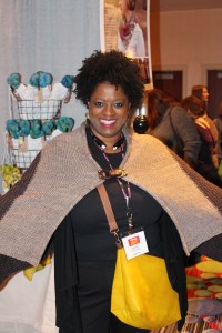 Knitter tries on Heidi & Lana's sample shawl with cool buckle. Available in kit.